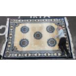 A Chinese washed woollen rug, traditionally decorated on a blue and white ground  108" x 170"