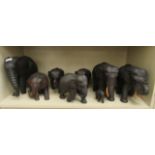 A modern carved wooden family of seven elephants  largest 10"h