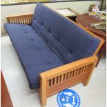 A modern slatted teak framed bed/settee with a part buttoned fabric cushioned, one piece back and