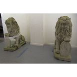 A pair of carved marble seated heraldic lions, each supporting an oval shield  48"h