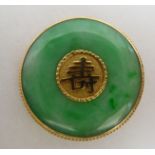 A gold coloured metal and jade set disc brooch, set with a Chinese character  stamped 10