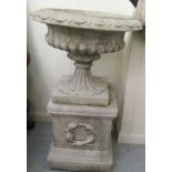 A composition stone terrace pedestal urn with egg and dart ornament, on a box plinth  40"h  26"dia