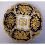 A Meissen gilded midnight blue glazed porcelain plate, decorated in high relief and reserves with