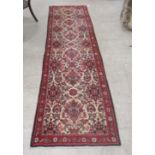 A Persian runner, profusely decorated with floral designs, on a multi-coloured ground  32" x 119"