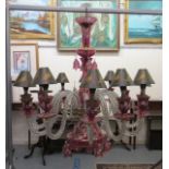 A 20thC clear cranberry coloured, gilded and floral overpainted chandeliers with thumb moulded S-