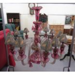 A 20thC clear cranberry coloured, gilded and floral overpainted chandelier with thumb moulded, S-