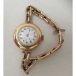 An early 20thC ladies 9ct gold cased wristwatch, faced by an Arabic dial, on a 9ct gold strap