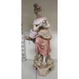 A Royal Dux porcelain figure, a young woman seated on a tree stump with a watering can and
