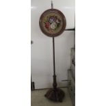 A mid Victorian string inlaid mahogany pole screen, set with a tapestry panel, on a stepped plinth