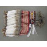 A Native American style headdress, decorated with beads, fabric, fur and feathers
