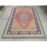 A Caucasian, machine made rug, decorated with stylised geometric shapes, on a multi-coloured ground