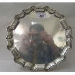 An Edwardian silver salver with a raised piecrust border, elevated on pad feet  Daniel & John Welby