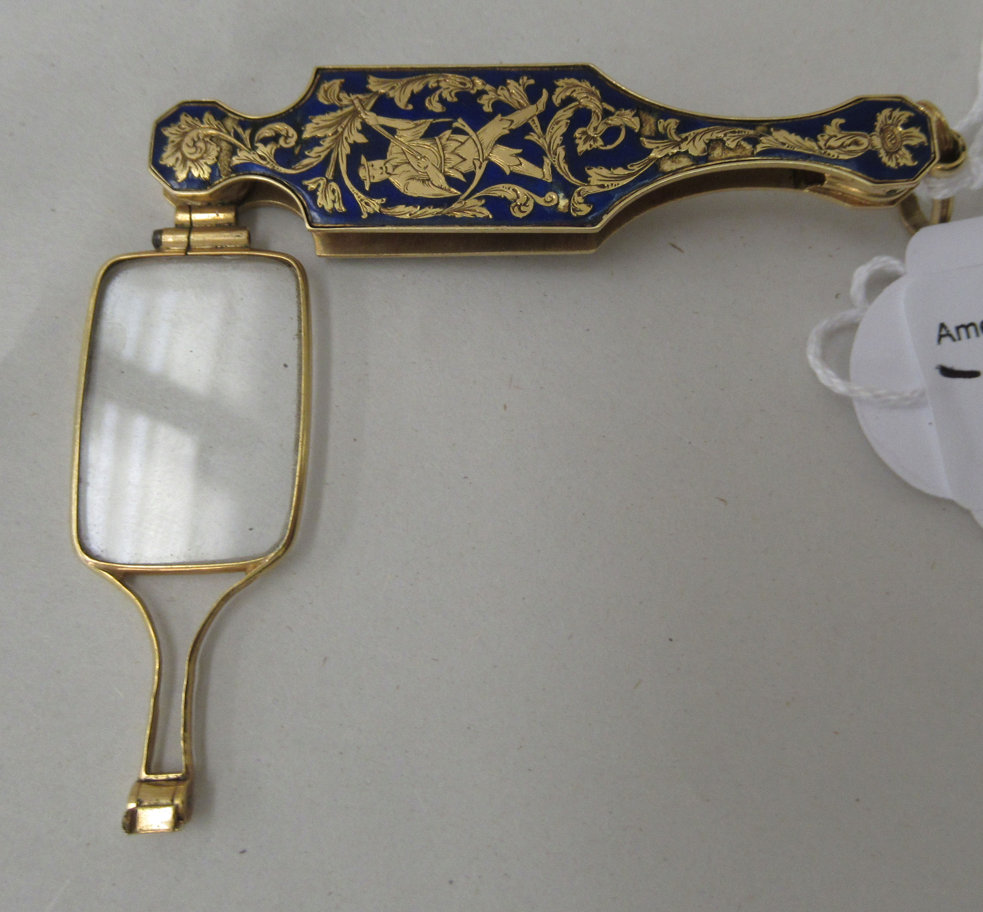 A gilt metal and enamel cased single lens lornette