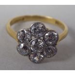 An 18ct gold floral design ring, set with seven diamonds