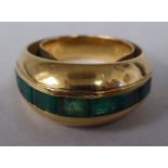 A yellow metal and emerald set dress ring