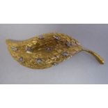 A textured yellow metal and diamond set leaf brooch