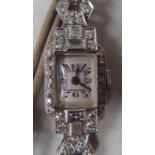 An Art Deco diamond encrusted platinum cased cocktail watch, faced by an Arabic dial