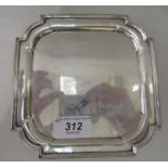 A silver teapot stand of rectangular design with an applied wire border and curved corners, elevated