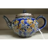 An early 20thC Doulton Lambeth blue, brown and green glazed stoneware bulbous teapot, having an