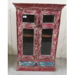 An antique finished, distressed, painted hanging cabinet with a pair of glazed doors, over a long