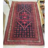 A Turkoman rug, decorated with stylised foliage, on a mainly dark blue and red ground  34" x 74"