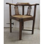 A mid/late 19thC oak and elm framed corner chair, the drop-in rush seat raised on square legs