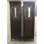 A pair of Art Nouveau oak cabinets, each with a tinted glass and mirrored lead glazed panel, over