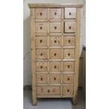A 20thC antique inspired Chinese shabby chic painted twenty drawer medicine cabinet, raised on block
