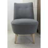 A modern grey fabric covered nursing/bedroom chair, raised on light oak legs