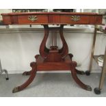 A modern Regency style fruitwood side table with a frieze drawer, over lyre shaped uprights,