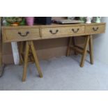 A modern fruitwood desk with three drawers, raised on two trestle ends  32"h  64"w