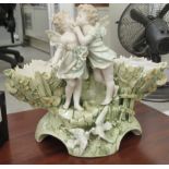 A late 19thC Continental porcelain centrepiece of basket design, surmounted by two embracing