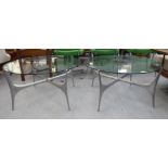 A pair of 1960s clear plate glass topped coffee tables, raised on crossover cast alloy legs  22"h