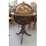 A modern stained beech and overpainted cocktail globe, on a tripod base  46"h  28"dia