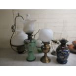 Early 20thC lighting: to include a glass oil lamp, overpainted with floral designs  23"h overall