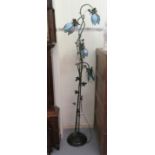 A modern cast metal standard lamp of organic design with four scrolled branches and blue glass