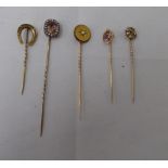 Five dissimilar gold and yellow metal stickpins: to include an 18ct gold example, incorporating a