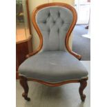A late Victorian walnut framed spoonback salon chair, upholstered in blue fabric, raised on cabriole
