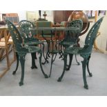 A modern Victorian style dark green painted iron patio table  29"h  30"dia; and a set of four