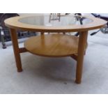 A Schreiber teak framed two tier coffee table, the upper level with an inset glass panel, raised