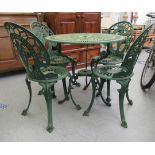 A modern green painted aluminium patio table, raised on scrolled legs  29"h  31"dia; and four