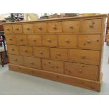 A modern waxed pine chest with an arrangement of twenty-two graduated drawers, on a plinth  35"
