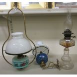 Victorian oil lamps: to include a wall mounted example with a blue glass reservoir, on a gilt