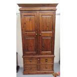 A modern stained pine wardrobe with two panelled doors and four base drawers, on a plinth  70"h