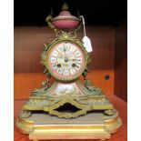 A late 19thC French gilded metal and painted porcelain cased mantle clock with a vase and apposing