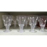 A set of eight early 20thC conical shaped drinking glasses with knopped decoration