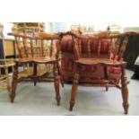 A pair of modern Victorian design oak framed captain chairs with solid seats raised on turned,