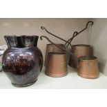 A graduated set of four 19thC style copper and riveted wrought iron measures; and a treacle glazed