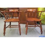 A pair of modern Victorian design oak framed captain chairs with solid seats raised on turned,