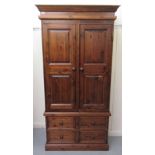 A modern stained pine wardrobe with two panelled doors and four base drawers, on a plinth  70"h